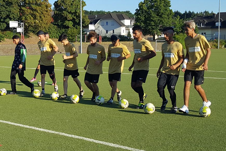 Personen beim Aufwärmen vor einem Fußballspiel.