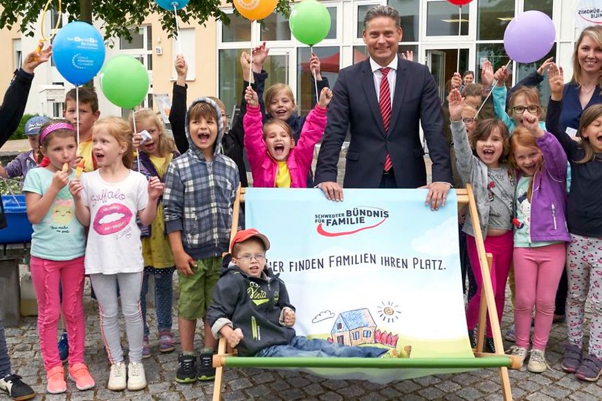 Kinder die sich freuen mit dem Staatssekretär Stefan Zierke in der Mitte. 