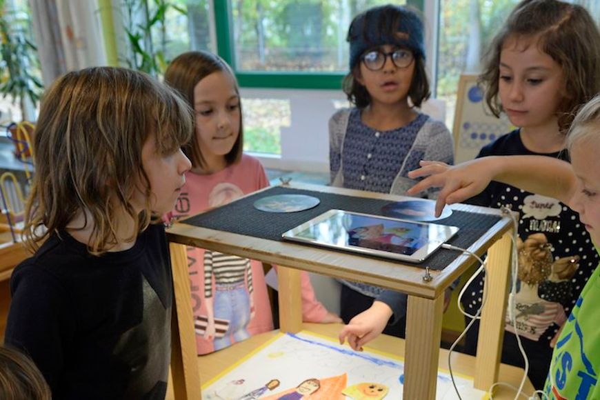 Kinder versammeln sich um ein iPad