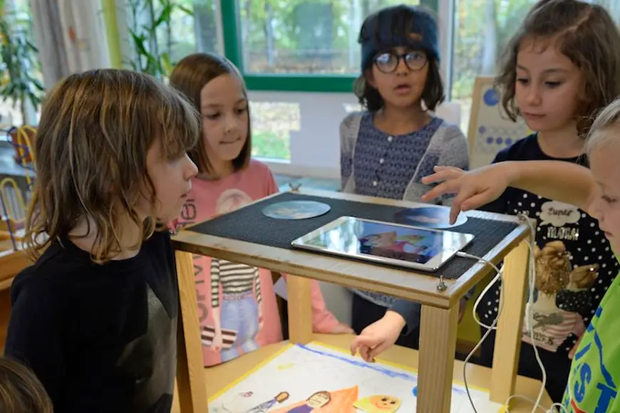 Kinder versammeln sich um ein iPad