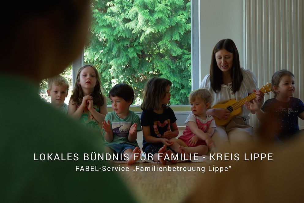 Kinder und Erzieherin machen Musik, Schriftzug "Lokales Bündnis für Familie Kreis Lippe"