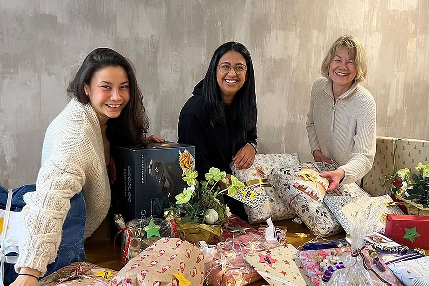 3 Frauen, vor ihnen Geschenke