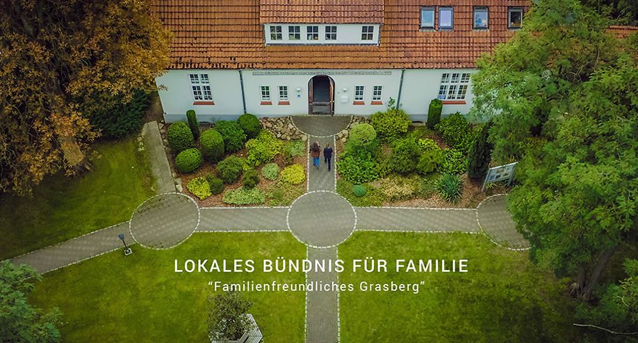 Aufnahme eines großen Hauses mit Park von oben mit dem Text " Lokales Bündnis für Familie - Familienfreundliches Grasberg"