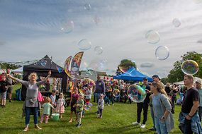 Menschen spielen mit Seifenblasen bei einem Fest des Strausberger Bündnis für Familie