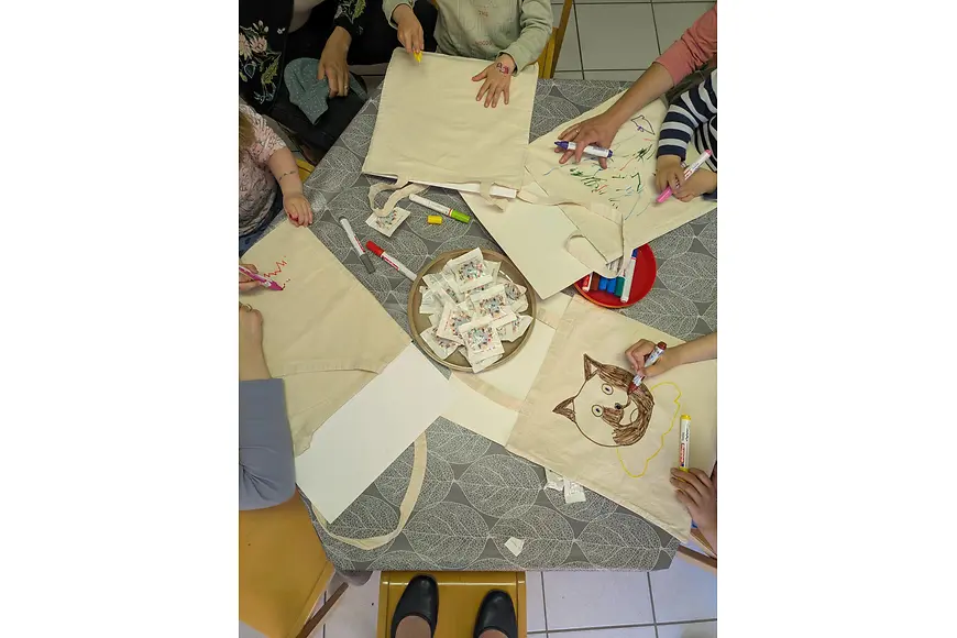 Ein Tisch mit Postkarten und Postern, die von Teilnehmenden gestaltet werden