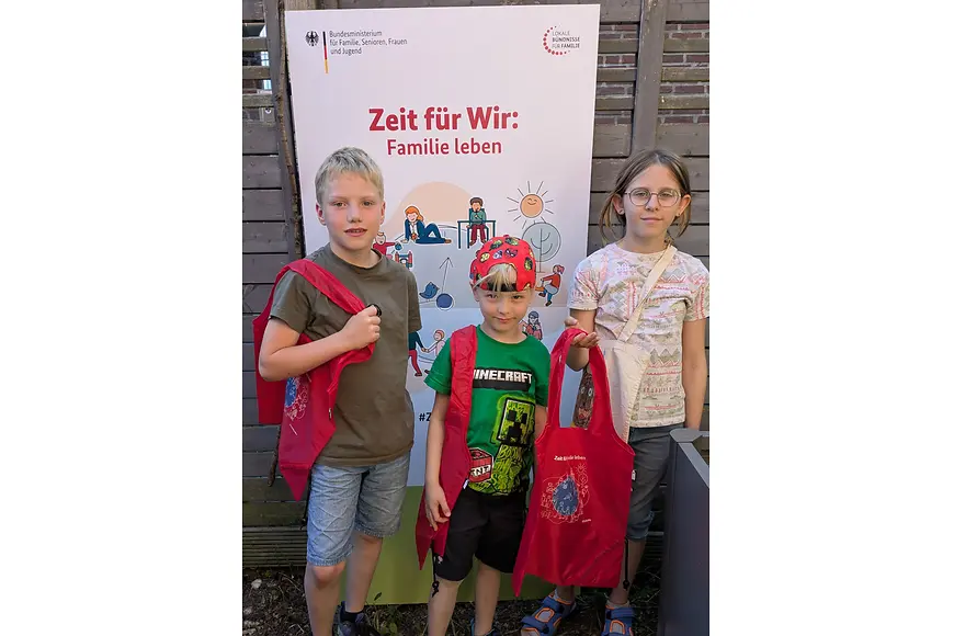 3 Kinder stehen vor dem Poster des Aktionstags