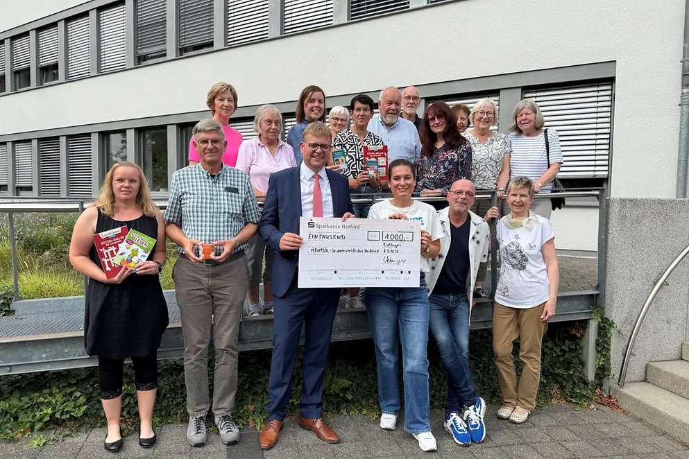 Einwohner der Gemeinde Kirchenlegern halten einen Scheck