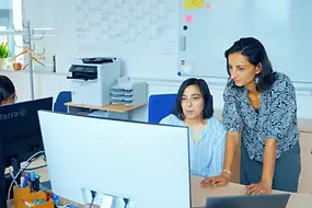 Zwei Frauen schauen gemeinsam auf einen Computer