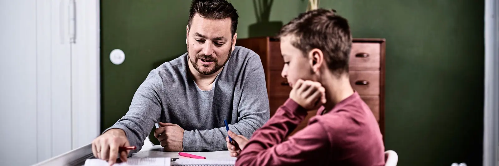 Ein Mann lernt mit einem Kind.
