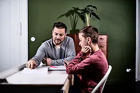 Ein Mann lernt mit einem Kind.